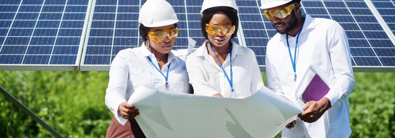 African american technician checks the maintenance of the solar African american technician checks the maintenance of the solar panels. Group of three black engineers meeting at solar station.